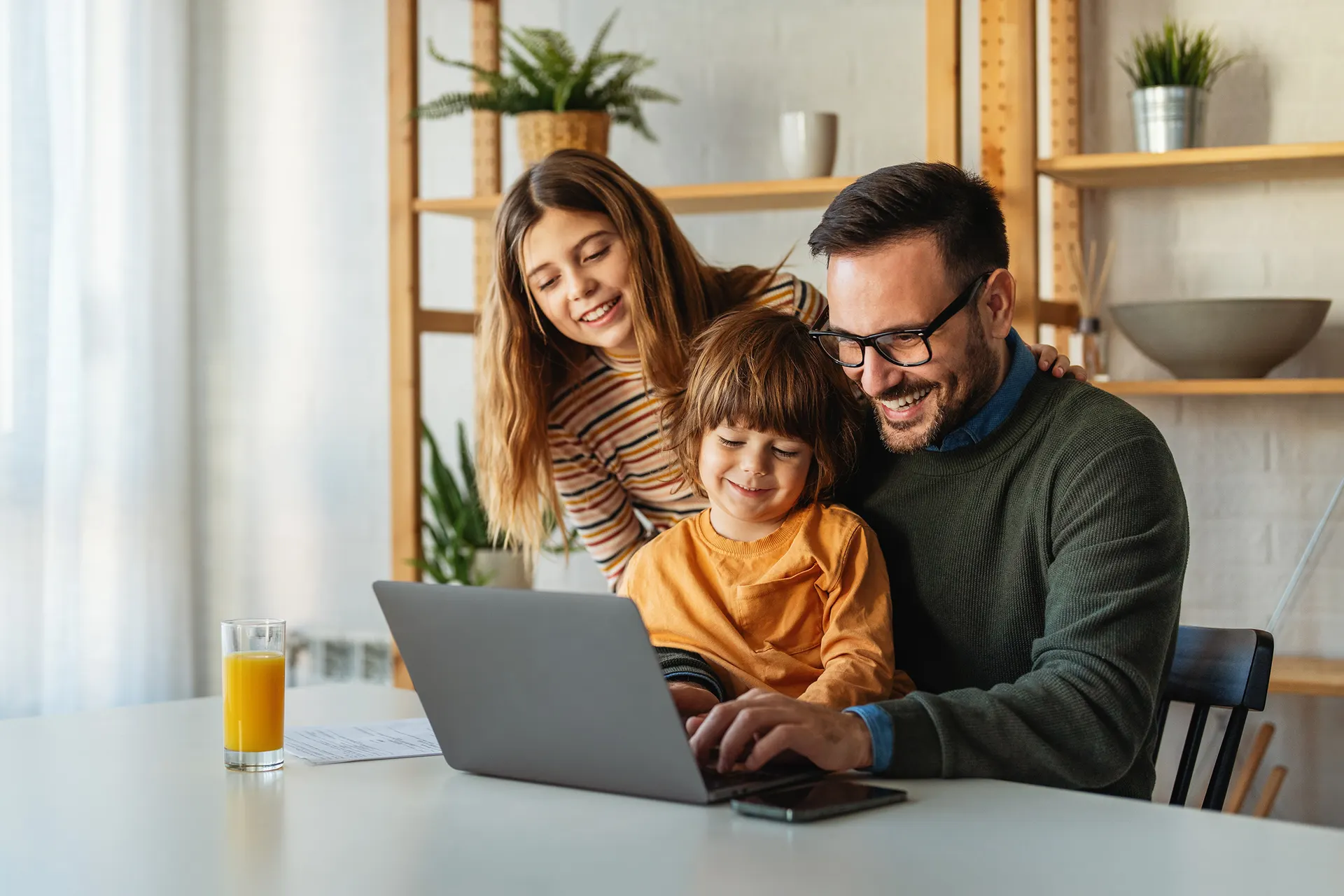 Familie plant ihre Photovoltaikanlage am Laptop