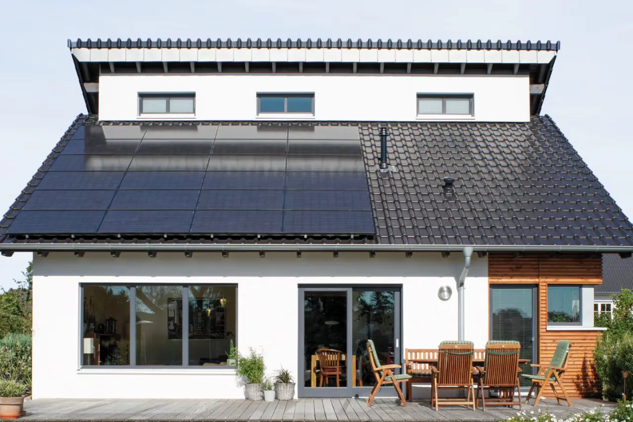 Schwarze Solarmodule auf dem Ziegeldach eines Einfamilienhauses